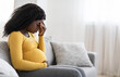 © Prostock-studio - Young pregnant black woman suffering from headache or migraine