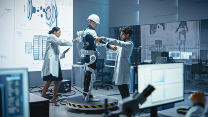 Poster - In Robotics Development Laboratory: Engineers and Scientists Work on a Bionics Exoskeleton Prototype with Person Testing it. Designing Wearable Exosuit to Help Disabled People, Warehouse Workers
