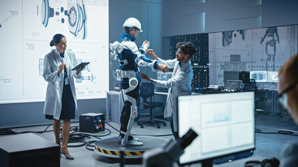 Poster - In Robotics Development Laboratory: Engineers and Scientists Work on a Bionics Exoskeleton Prototype with Person Testing it. Designing Wearable Exosuit to Help Disabled People, Warehouse Workers