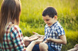 © Dmytro Titov - mom and son are playing on a summer green meadow. Active walk in the park