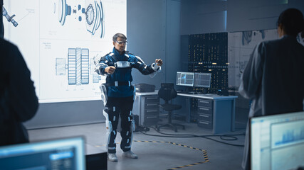 Poster - In Development Laboratory: Engineers and Scientists Look at Robotics Exoskeleton Prototype Presentation with Person Testing it, Performing and Standing. Designing Wearable Exosuit to Help People