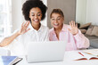 © Drobot Dean - Multicultural girls waving hands while doing homework with laptop