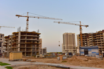 Tower cranes in action at construction site. Construction of skeleton of new modern residential buildings. Preparing to pour of concrete into formwork. Erection multi-storey residential building