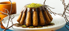 Banner Of Autumn Pumpkin Bundt Cake With Fried Poppy Seeds And Caramel On A White Plate With Pistachio