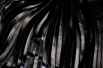Close-Up pleated and silver foil printed black fabric. Material textile and leather.