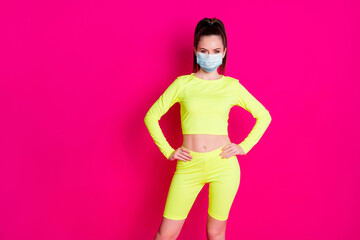 Sticker - Photo of cheerful sweet young woman dressed sportwear mask hands arms waist isolated pink color background