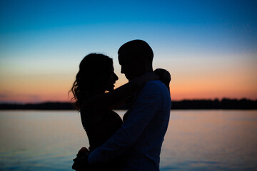 silhouettes of a couple in love romance at sunset