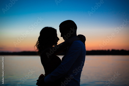 Fotografía Silhouettes of a couple in love romance at sunset