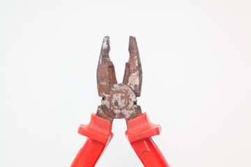 Wide open rusty red pliers against white background