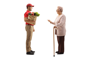 Canvas Print - Elderly woman talking to a food delivery man with a grocery bag