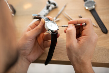 the watchmaker is repairing the mechanical watches in his workshop