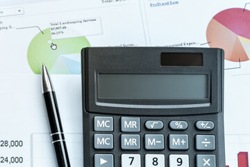 black calculator and pen on financial business graph paper office work concept