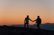 © MANUEL - Silhouette of a gay couple holding hands walking at sunset.