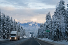 Truck Driving Through The Rocky Mountains In  Winter On The Trans Canada Highway In British Columbia Near Rogers Pass With Good Road Conditions Snowy Winter Mountain  Landscape Scenery As Backdrop