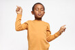© Anatoliy Karlyuk - Handsome African boy playing active game keeping eyes closed, pointing fore fingers at opposite directions. Adorable dark skinned little child meditating having calm peaceful facial expression