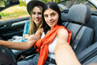 © F8  \ Suport Ukraine - Two young beautiful women are doing a photo of yourself in a convertible car