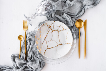 Wedding or festive table setting. Plates and cutlery with gray decorative textile on white background. Beautiful arrangement.