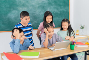 asian children group study in classroom, students feeling happy in education time, they do work and do project with laptop together on blackboard background, education technology, elementary school