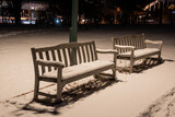 Fototapeta Miasto - 雪に覆われた冬の夜の公園のベンチ
