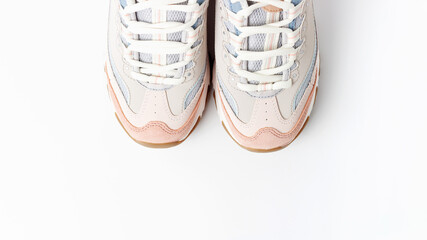 Pastel sneakers on white background copy of space, top view