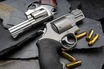 Revolver handguns on black stone background