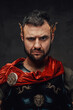 Serious and bearded roman emperor dressed in dark armour and red cloak