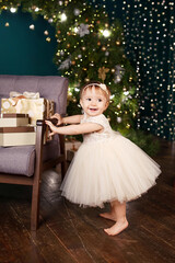 christmas and new year celebration concept. pretty little girl in white dress playing and being happ