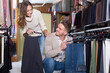 © JackF - Loving couple deciding on new trousers in men cloths store