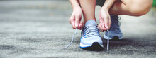 Running Shoes. Close Up Female Athlete Tying Laces For Jogging On Road. Runner Ties Getting Ready For Training. Sport Lifestyle. Copy Space Banner.