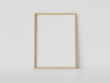 © sdecoret - Wooden frame leaning on white floor in interior mockup. Template of a picture framed on a wall 3D rendering