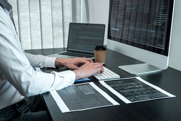 Wall Mural - young programmer working in software javascript computer in it office, writing codes and data code w