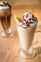 Two Iced coffee milkshake on a wood table with a wood background