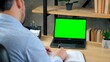 © viacheslav - Over the shoulder. Businessman CEO manager at home office writes information with pen in notebook. Green screen laptop computer concept: online remote distance education by video call chat conference
