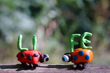 Canvas Print - Two figures of ladybirds made of plasticine. Next to it is the inscription life.