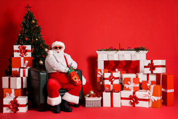 Sticker - Portrait of his he attractive fat overweight funky amazed stunned Santa sitting in armchair packing gifts for children holly jolly isolated bright vivid shine vibrant red color background