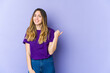 © Asier - Young caucasian woman isolated on purple background shocked pointing with index fingers to a copy space.