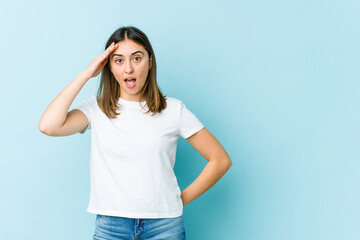 Young caucasian woman shouts loud, keeps eyes opened and hands tense.