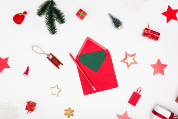 Canvas Print - top view of red envelope with card and pencil near christmas baubles and baked stars on white