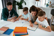 © JustLife - Parents helping the kids with their homework. Litlle boys learning at home