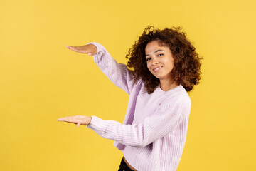 Young afro american woman on yellow copy space background