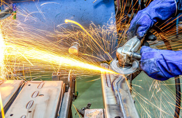 worker cutting steel with grinder