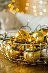 Golden Christmas balls with a light garland in the basket