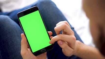 Wall Mural - compositing the hands of a man on laptop A black smartphone with background, green screen for chroma key Horizontally of Internet commerce and the use of online banking