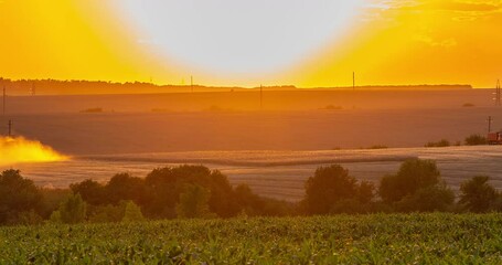 Wall Mural - Agriculture. Combine harvester working on a wheat field at sunset. Seasonal harvesting the wheat. Dusty field from the work of grain harvesting equipment. Silhouette tractor in the sunlight Time lapse