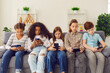 © Studio Romantic - Group of unhappy children play online games or read social networks on mobile phones.