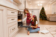 © Tina kids photo - Two little girl sisters cook at home Christmas dinner for Christmas