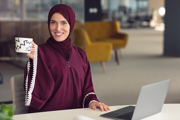 Wall Mural - Young Arabic business woman wearing hijab,working in her startup office. Diversity, multiracial concept