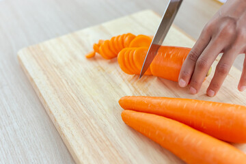 Wall Mural - Fresh carrot and cut pieces on wooden cutting board