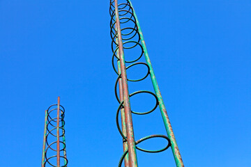 two towers of rebar rising against the blue sky