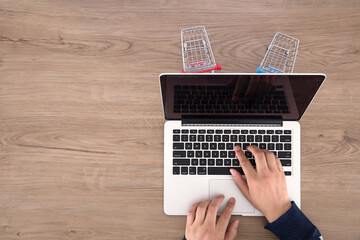 Wall Mural - Laptop and two shopping cart models in operation